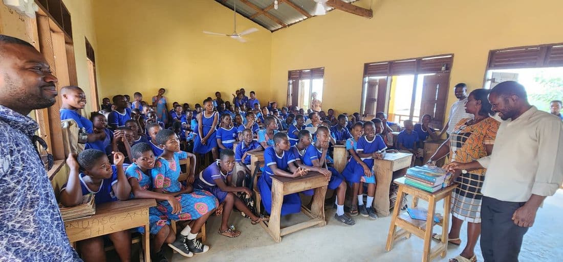 A wide view of a classroom full of school children in uniform during a foundation visit